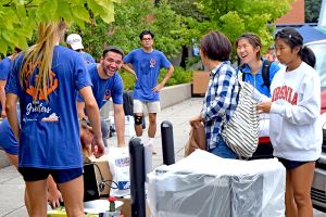 UVA Greeters at Move In wearing blue T shirts and helping students carry items